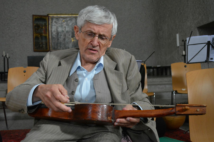 Rahmin Oruç Güvenç bir konser öncesinde kılkopuzunu tamir ediyor. 2 Ekim 2014, Avusturya.